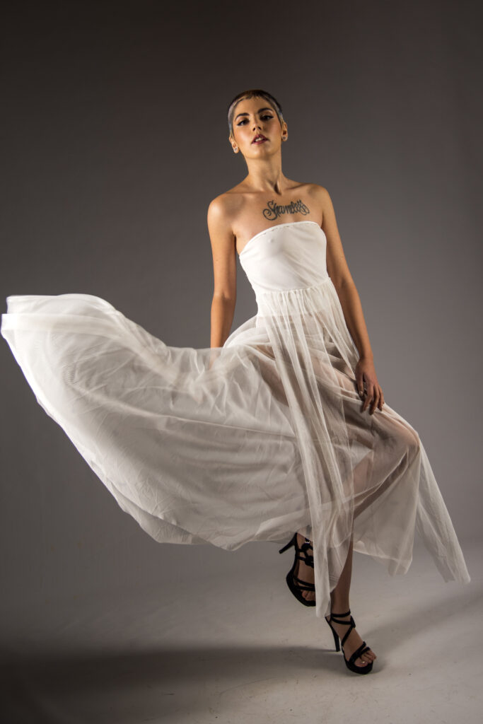 Fashion model wearing flowing white dress and high heels posing in studio. Photo By Morgan Capasso, Model Rossana Morra